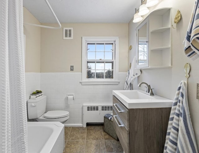 full bathroom featuring radiator heating unit, tile walls, vanity, toilet, and tile patterned floors