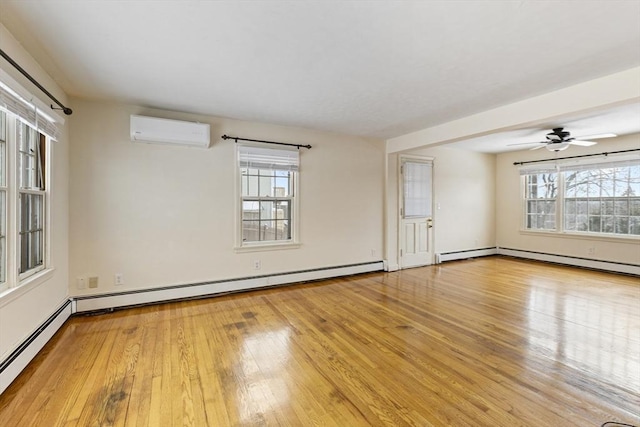 unfurnished room with a baseboard radiator, light wood-type flooring, ceiling fan, and a wall unit AC