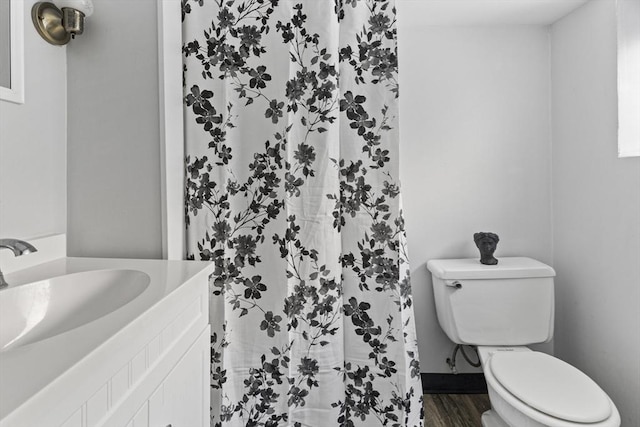 bathroom featuring hardwood / wood-style flooring, vanity, a shower with shower curtain, and toilet