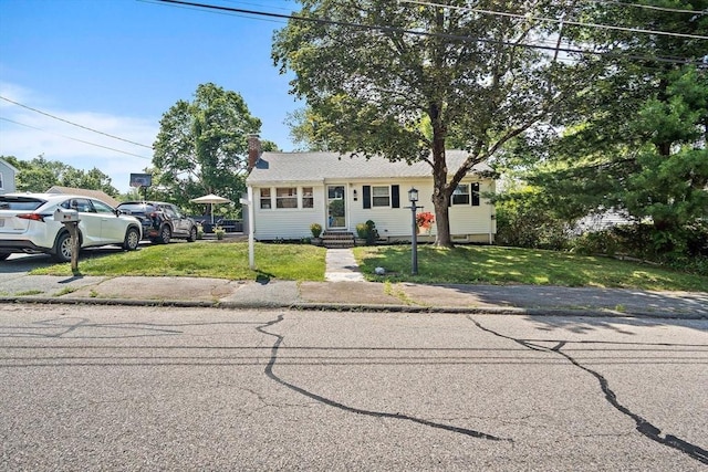 11 Worcester Pl, Holbrook, MA 02343 - view of front of property featuring a front yard and a chimney