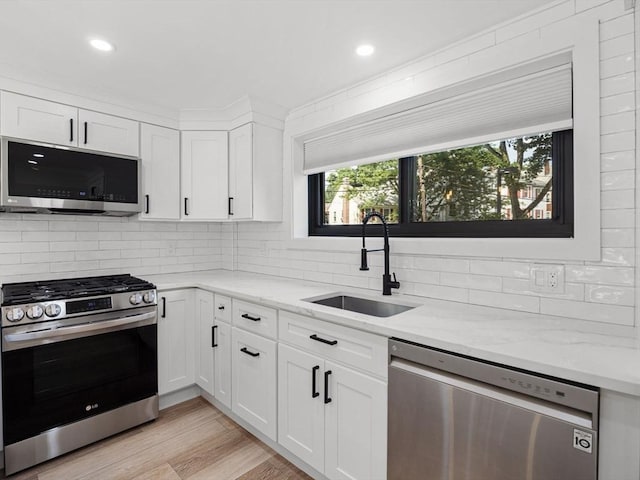 22 Chestnut Pl Unit G1, Brookline, MA 02445 - kitchen featuring stainless steel appliances, backsplash, light stone counters, and recessed lighting