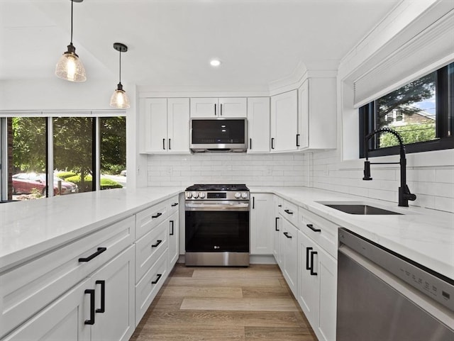 22 Chestnut Pl Unit G1, Brookline, MA 02445 - kitchen with stainless steel appliances, tasteful backsplash, white cabinets, recessed lighting, and light stone countertops