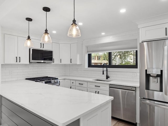 22 Chestnut Pl Unit G1, Brookline, MA 02445 - kitchen with appliances with stainless steel finishes, a peninsula, tasteful backsplash, white cabinetry, and recessed lighting