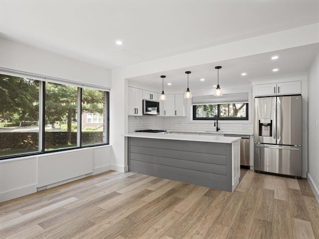 22 Chestnut Pl Unit G1, Brookline, MA 02445 - kitchen with appliances with stainless steel finishes, healthy amount of natural light, light countertops, backsplash, and recessed lighting