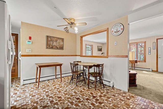 dining area with baseboard heating, ceiling fan, and plenty of natural light