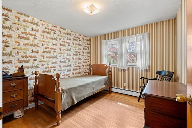 bedroom featuring wallpapered walls, baseboard heating, and light wood-type flooring