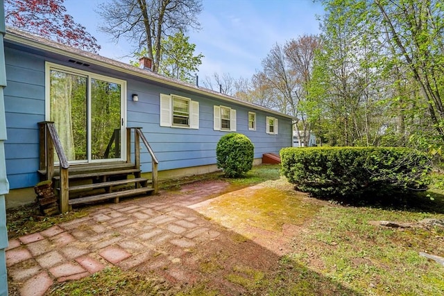 rear view of property featuring entry steps and a chimney