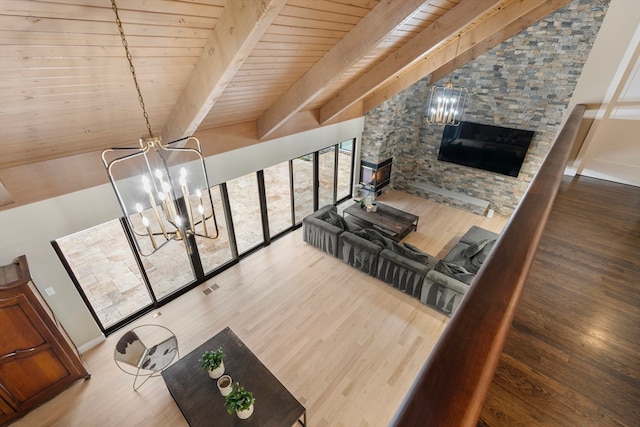 living room with dark hardwood / wood-style flooring, lofted ceiling with beams, and a chandelier