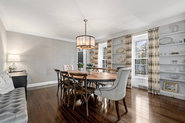 dining room with dark wood-type flooring, crown molding, and a chandelier