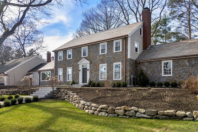 colonial house featuring a front lawn