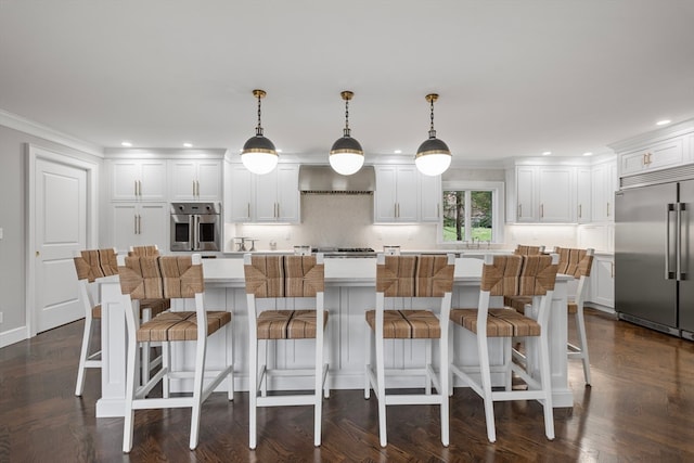 kitchen featuring decorative light fixtures, wall chimney range hood, stainless steel appliances, and dark parquet floors