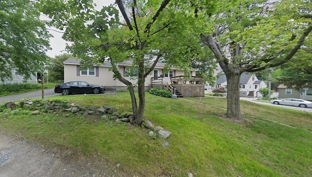 view of front of house with a deck and a front lawn