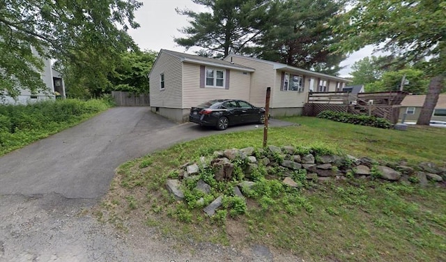 view of front of property with a wooden deck and a front lawn