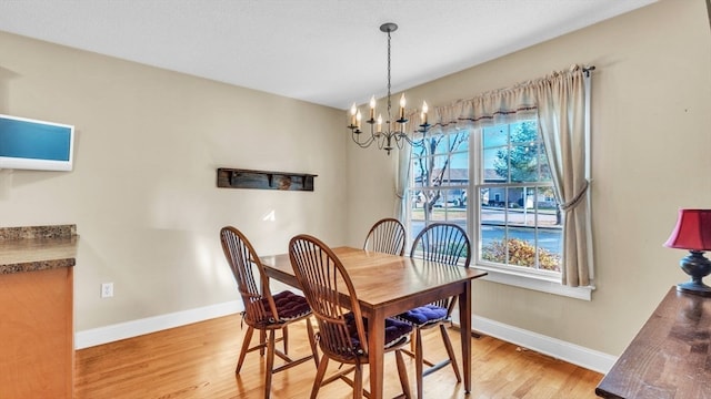 dining area featuring light hardwood / wood-style floors and a notable chandelier