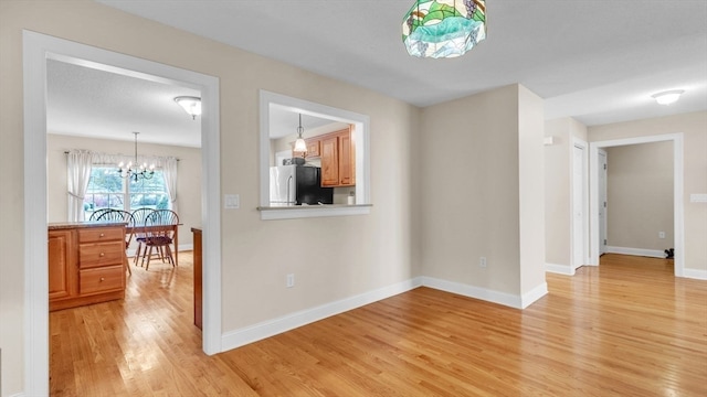 interior space with light hardwood / wood-style floors and a notable chandelier