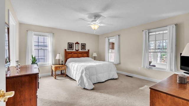 carpeted bedroom with multiple windows, a textured ceiling, and ceiling fan