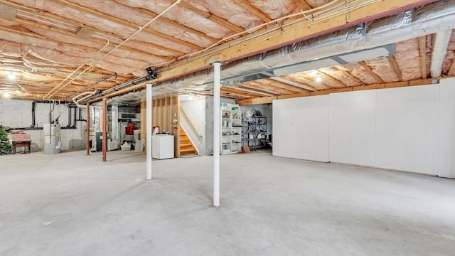 basement featuring water heater and washer / dryer