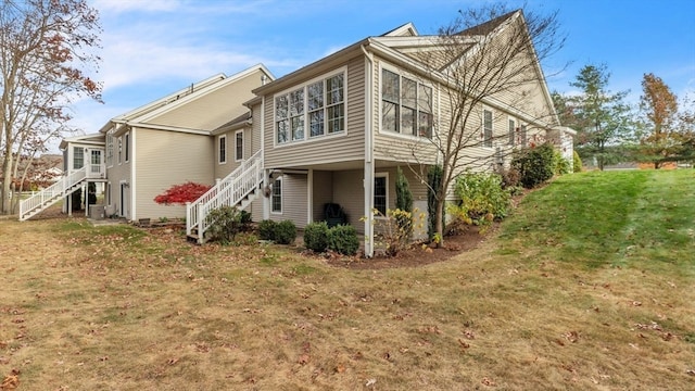 rear view of house featuring central air condition unit and a lawn