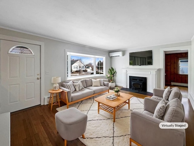 living room with dark wood finished floors, baseboard heating, a wall mounted AC, and a healthy amount of sunlight