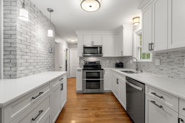 37 Benjamin, Marlborough, MA 01752 - kitchen featuring stainless steel appliances, a sink, tasteful backsplash, light wood-style floors, and white cabinetry