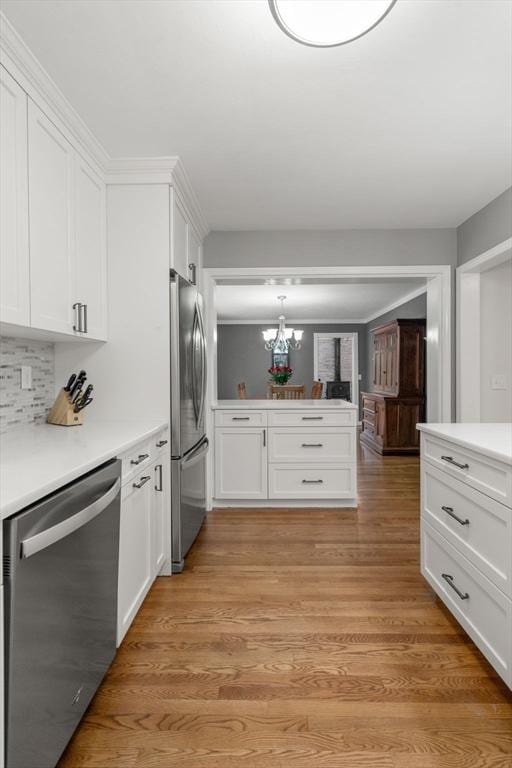 37 Benjamin, Marlborough, MA 01752 - kitchen featuring appliances with stainless steel finishes, white cabinets, light countertops, and a chandelier