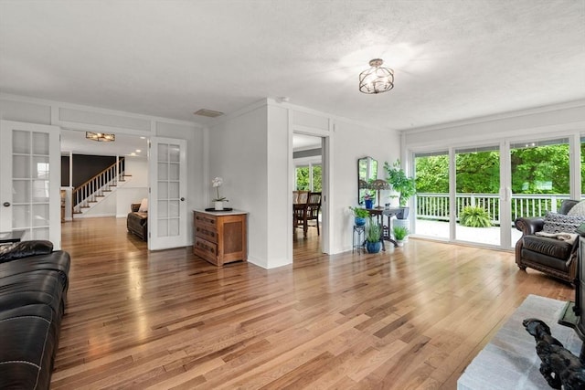37 Benjamin, Marlborough, MA 01752 - living room with french doors, a chandelier, light wood-type flooring, stairs, and baseboards