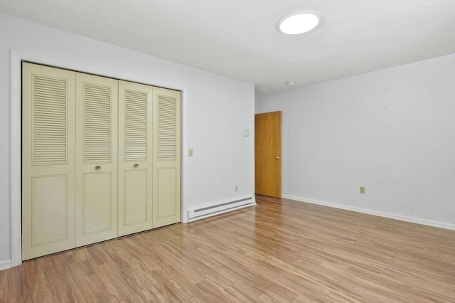 2-4 Founders Rd, Shrewsbury, MA 01545 - unfurnished bedroom with baseboard heating, light wood-style flooring, and a closet