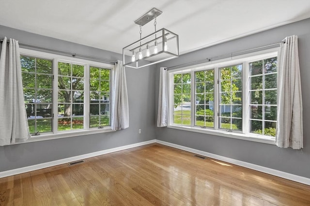 2-4 Founders Rd, Shrewsbury, MA 01545 - unfurnished dining area with healthy amount of natural light, a chandelier, and wood finished floors