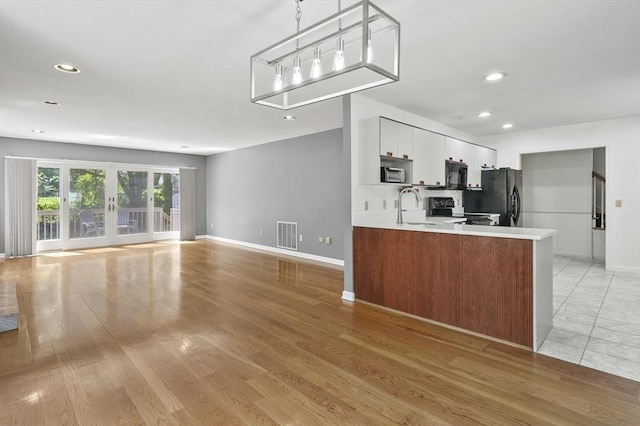 2-4 Founders Rd, Shrewsbury, MA 01545 - kitchen with black appliances, light countertops, a peninsula, recessed lighting, and light wood finished floors