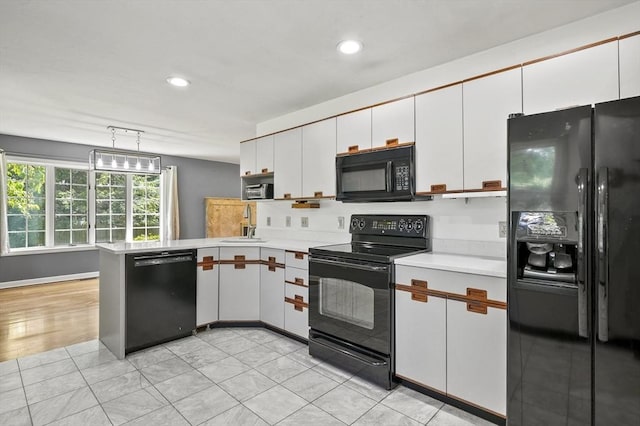 2-4 Founders Rd, Shrewsbury, MA 01545 - kitchen with black appliances, light countertops, a peninsula, white cabinets, and recessed lighting