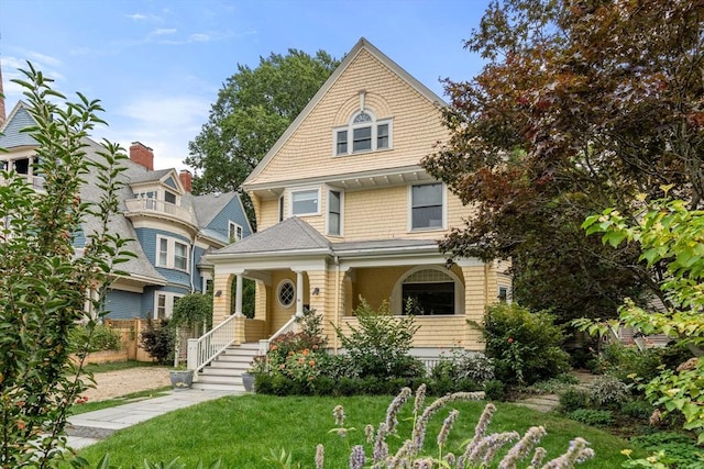 view of front of property featuring covered porch and a front lawn