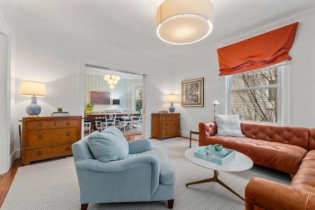 living area with a chandelier, a healthy amount of sunlight, crown molding, and baseboards