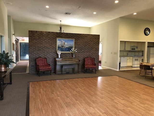 living room featuring high vaulted ceiling and light hardwood / wood-style flooring