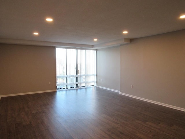 unfurnished room with dark hardwood / wood-style flooring and floor to ceiling windows