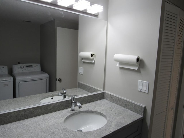 bathroom with vanity and separate washer and dryer