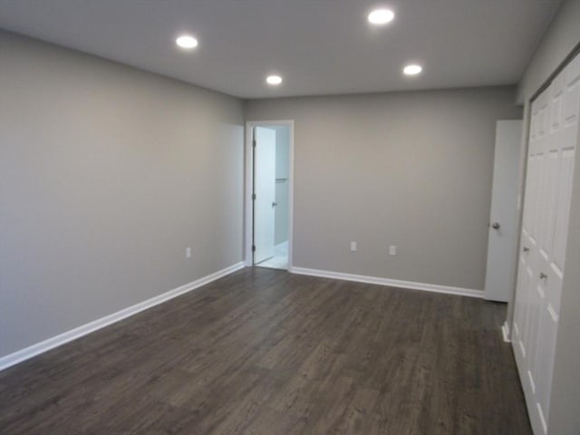 unfurnished bedroom featuring dark wood-type flooring and a closet