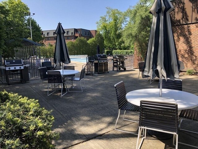 view of patio with a community pool and a grill