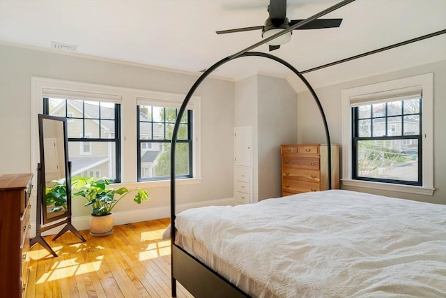 bedroom with baseboards, ornamental molding, and hardwood / wood-style floors