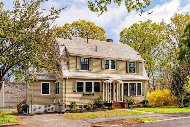 view of front of property featuring a chimney and a gambrel roof
