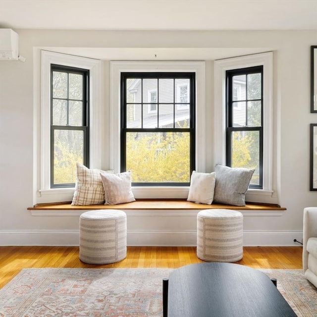 sitting room featuring light wood-style floors, baseboards, and plenty of natural light