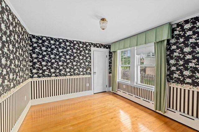 178 Elliot Ave, Quincy, MA 02171 - spare room featuring wallpapered walls, baseboard heating, ornamental molding, and light wood-type flooring