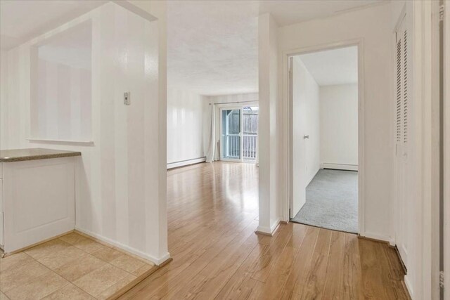 205 Independence Ave Unit 223, Quincy, MA 02169 - hall with a baseboard heating unit, light wood-style floors, and baseboards