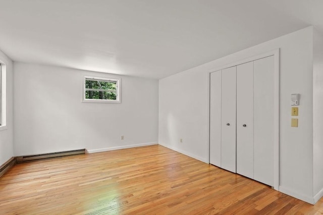 155 Glen Charlie Rd, Wareham, MA 02538 - unfurnished bedroom featuring a baseboard heating unit, light wood-type flooring, and a closet