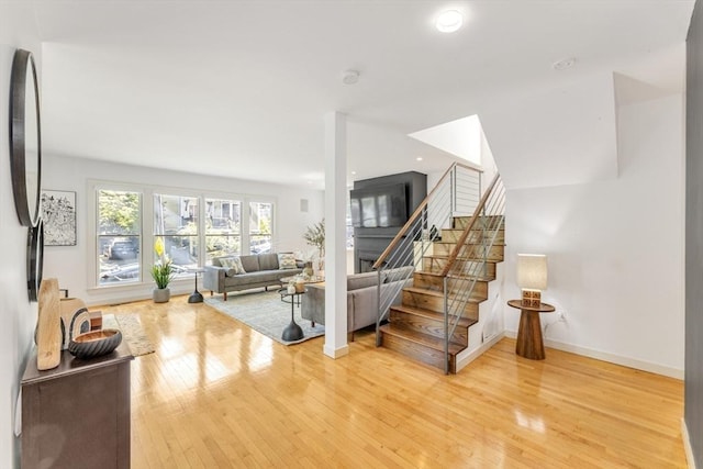 staircase with wood finished floors, baseboards, and recessed lighting