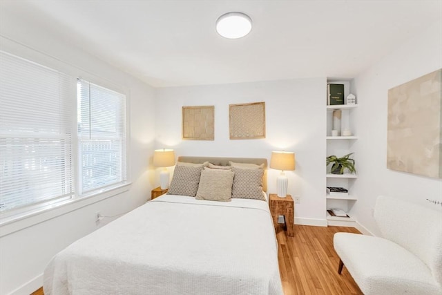 bedroom with light wood-type flooring and baseboards