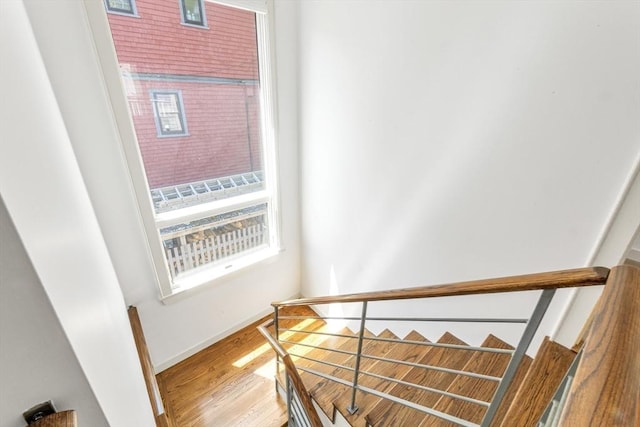 stairway with wood finished floors and baseboards