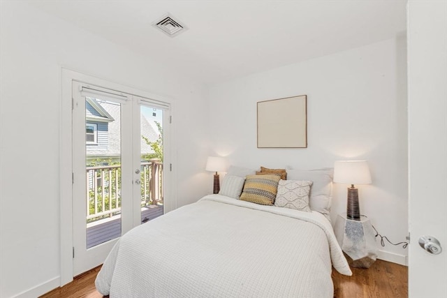 bedroom with access to exterior, light wood-type flooring, and baseboards