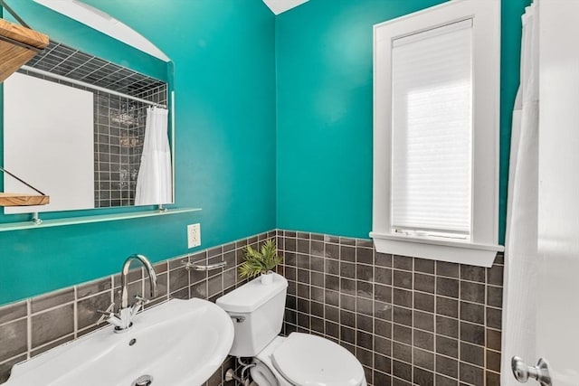 bathroom featuring a sink, tile walls, toilet, and a shower with curtain