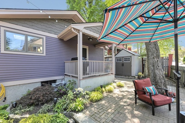 view of patio with a storage unit, an outdoor structure, and fence