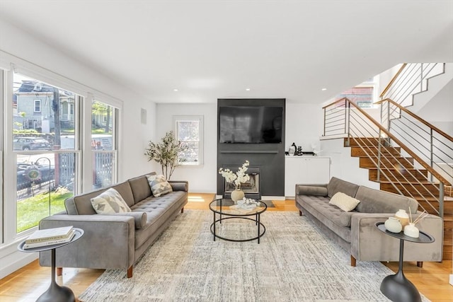 living room featuring stairs, healthy amount of natural light, and wood finished floors